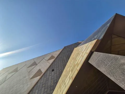 Modern building facade with geometric architecture under clear blue sky Stock Photos