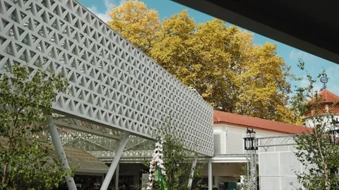 Modern building facade with geometric pattern and outdoor event setup Stock Footage 345848345