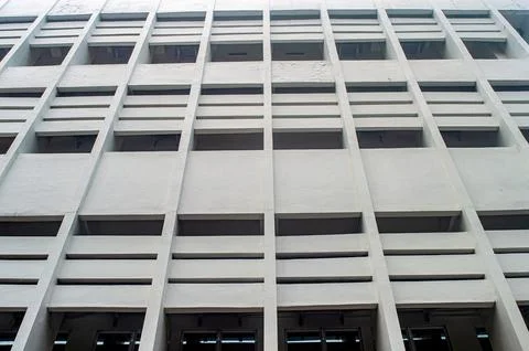 A modern building facade with a grid like pattern of windows and concrete b.. Stock Photos