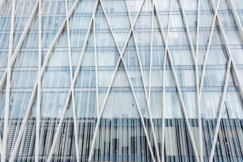 Modern building facade with intersecting white diagonal lines and glass panel Fotos de archivo