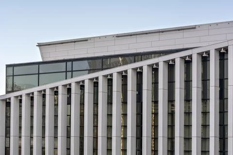 A modern building facade with large vertical glass and metal panels forming a Stock Photos