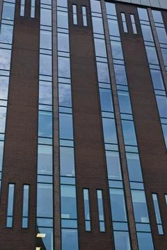 Modern building facade with a pattern of windows and brickwork against a bl.. Fotos de archivo
