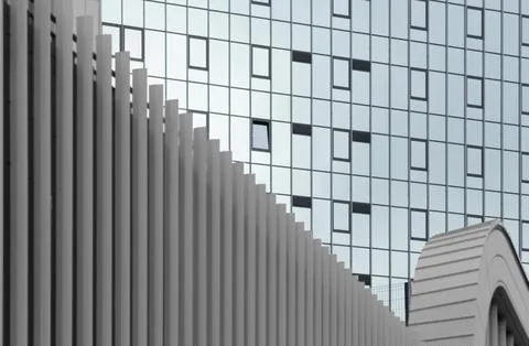 Modern building facade with repeating columns and glass windows. Geometric Stock Photos
