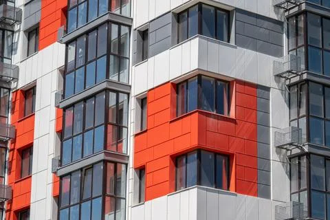 Modern building facade showcasing vibrant red accents with large glass wind.. Stock Photos