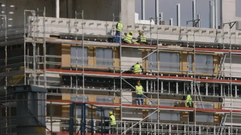 Modern building facade under construction with workers on scaffolding 스톡 동영상 333651886