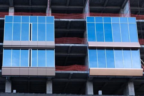 Modern building facade under construction with blue glass panels Stock Photos