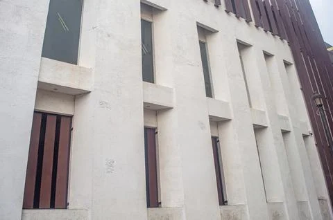 A modern building facade with vertical windows and white concrete columns, .. Stock Photos