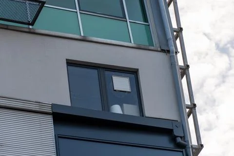Modern building facade with window, ventilation grille, gutter and metal stru Stock Photos