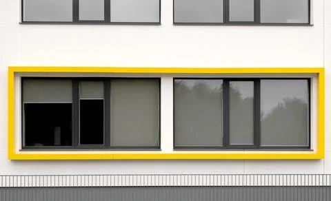 Modern building facade with yellow window detail Stock Photos