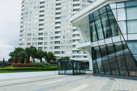 A modern building features striking design elements near a tall apartment com 写真素材