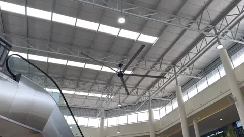 Modern Building Interior with Escalator and Industrial Ceiling Fan Stock Footage 332096543
