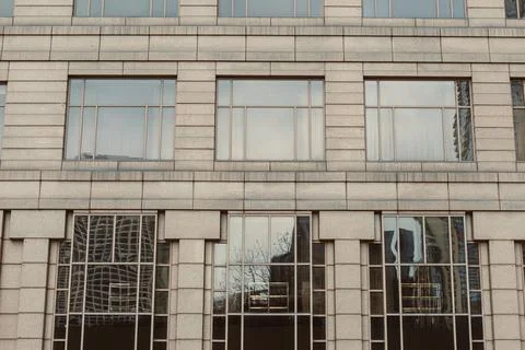 Modern building with large windows reflecting city life during daylight hours Stock Photos