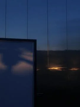 Modern building reflecting clouds at dusk Stock Photos