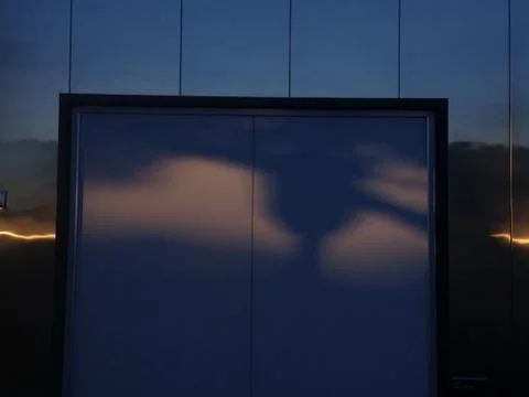 Modern building reflecting clouds at dusk Stock Photos