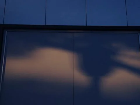 Modern building reflecting clouds at dusk Stock Photos