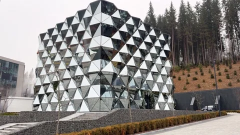 Modern building with reflective triangular facade near forest Stock Footage 307721954