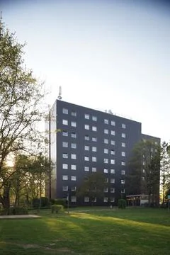 Modern building with square windows, facade in dark gray, with sunset in the Foto stock