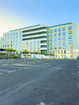 A modern building stands in the background with multiple windows. The parking Stock Photos