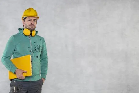Modern building supervisor keeps the computer in his hands, technology at wor Stock Photos