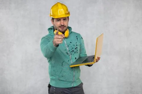 Modern building supervisor keeps the computer in his hands, technology at wor Stock Photos
