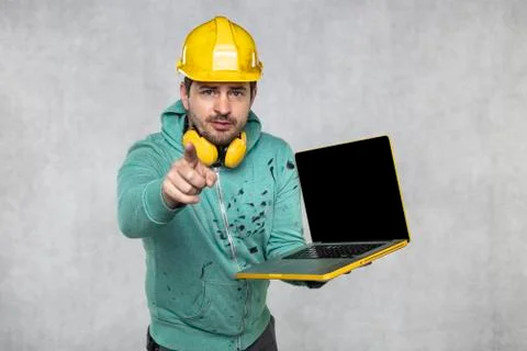 Modern building supervisor keeps the computer in his hands, technology at wor Foto stock