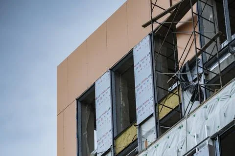 Modern Building Under Construction With Facade Installation and Scaffolding Stock Photos
