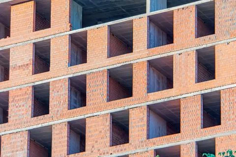 Modern building under construction, red-orange brick walls, horizontal rows,  Stock Photos