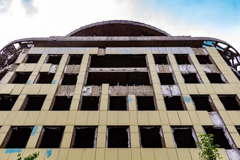 Modern building under construction with yellow facade panels and empty windows Stock Photos