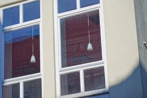 Modern building windows reflecting interior lights and exterior shadows on wa Stock Photos