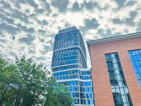 Modern buildings stand under a cloudy sky on a bright day in an urban area Foto stock
