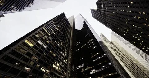 Modern buildings stretching towards cloudy sky in urban setting Ilustración de archivo