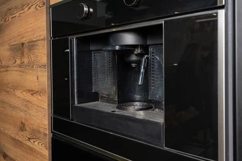 A modern built-in coffee machine seamlessly integrated into a wood veneer kit Fotos de archivo