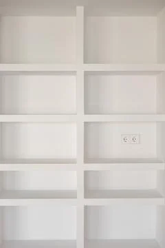 Modern built-in white shelving with structured symmetrical layout Stock Photos