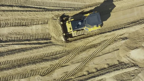 Modern bulldozer moves sand preparing smooth surface Видео 276242022