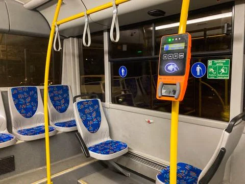 A modern bus interior with spacious seating, patterns on seats, information d Stock Photos