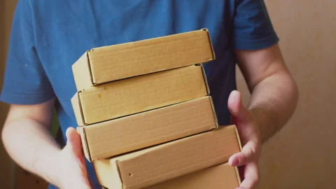 Modern business. Courier with a stack of cardboard boxes in his hands. Close-up 스톡 동영상 275523754