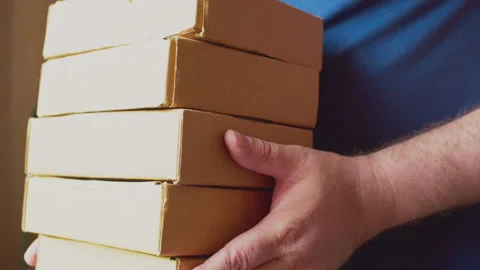 Modern business. Courier with a stack of cardboard boxes in his hands. Close-up 스톡 동영상 276705492