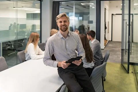 Modern business man in formalwear using digital tablet while standing in th.. Stock Photos