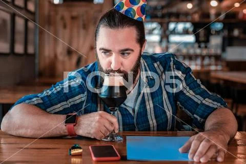 Modern businessman wearing smart watch drinking beer in bar Stock Photos