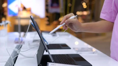 Modern buyer chooses graphics tablet from models in hardware store. Graphic Stock Footage 257432453
