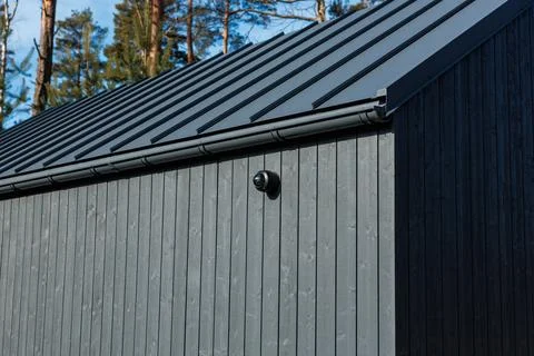 Modern cabin eave with dome security camera and metal roof Stock Photos