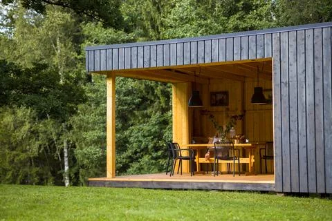 Modern cabin in a tranquil forest setting. Contemporary design blends with na Stock Photos