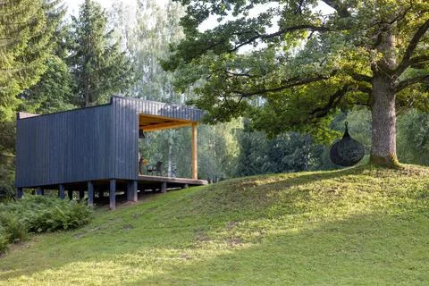 Modern cabin in a tranquil forest setting. Contemporary design blends with na Stock Photos