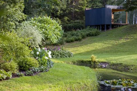 Modern cabin in a tranquil forest setting. Contemporary design blends with na Stock Photos