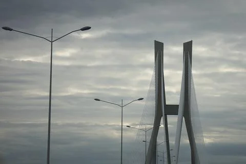 Modern cable-stayed bridge pylon rising against a dramatic overcast sky wit.. Stock Photos