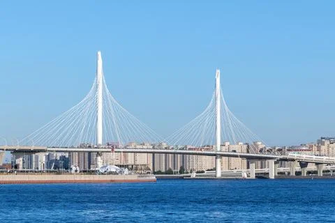 A modern cable-stayed bridge rises above blue water against a clear sky Fotos Stock