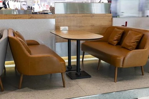 Modern cafe seating with leather sofas and wooden table Stock Photos