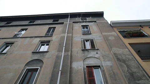 A modern cafe with a tent at the bottom of an old house with arched windows Stock Footage 128949561