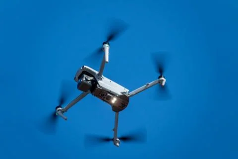 Modern Camera Drone Flying Against Clear Blue Sky. Aerial Photography Techn.. Stock Photos
