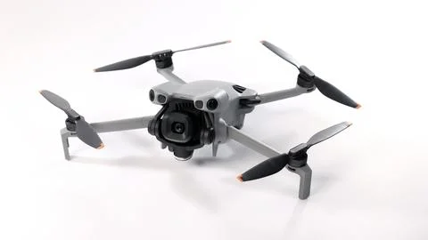 Modern camera drone with remote controller on white background. Photos